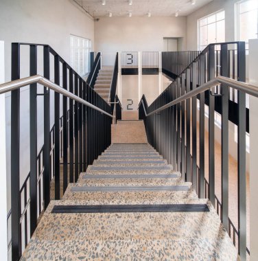 Güneşli bir günde üçüncü katta merdivenlerdeyiz.