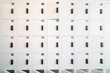 Büyük bir binanın koridorunda küçük beyaz dolaplar var.