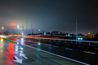 Yağmurlu ve karanlık bir sabahta işlek cadde ve trafik ışıklarıyla bu yeni köprü