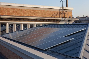 Yerleşim alanındaki bir binada bulutlu bir günde çatıda güneş panelleri vardır.