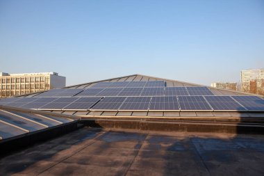 Yerleşim alanındaki bir binada bulutlu bir günde çatıda güneş panelleri vardır.