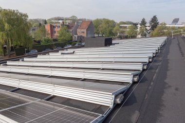 Konut alanındaki bir binada güneşli bir günde çatıda güneş panelleri var.