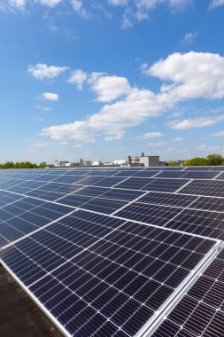 Konut alanındaki bir binada güneşli bir günde çatıda güneş panelleri var.