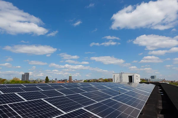 Konut alanındaki bir binada güneşli bir günde çatıda güneş panelleri var.