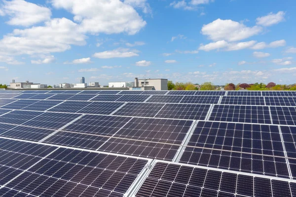 Konut alanındaki bir binada güneşli bir günde çatıda güneş panelleri var.