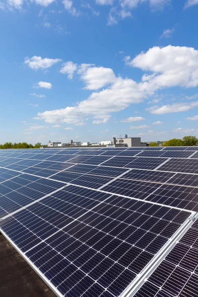 Konut alanındaki bir binada güneşli bir günde çatıda güneş panelleri var.