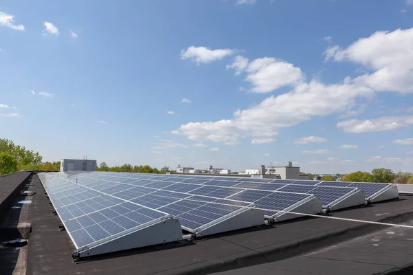 Konut alanındaki bir binada güneşli bir günde çatıda güneş panelleri var.