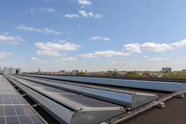 Konut alanındaki bir binada güneşli bir günde çatıda güneş panelleri var.