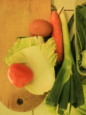 Mutfakta sebze, domates, havuç ve yumurta ile pişirilmeye hazır çeşitli sebzeler var..