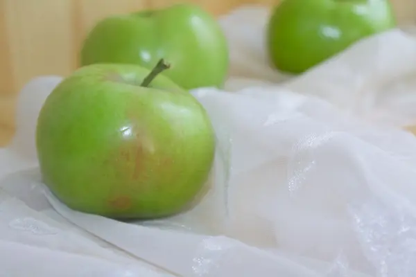 Grönt äpple på en ljus bakgrund — Stock fotografie