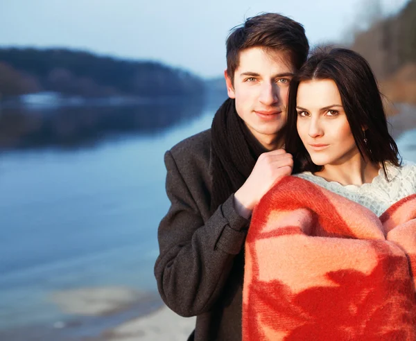 Ragazzo e ragazza in piedi vicino all'acqua in vestiti caldi . — Foto Stock