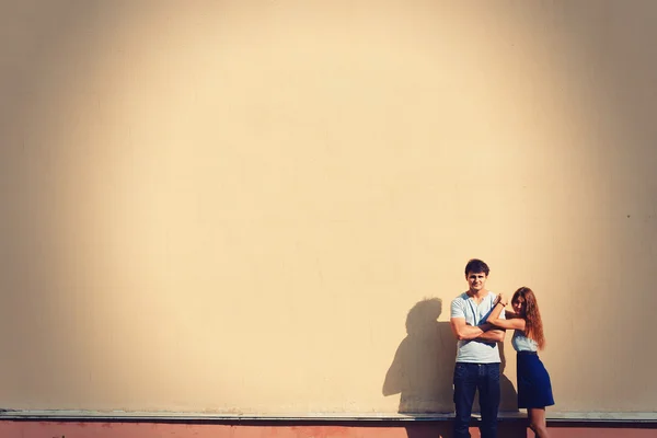 Gelukkige jonge paar en huis met grote muur — Stockfoto