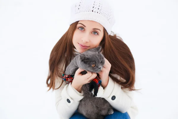 Vacker kvinna med katt på vintern — Stockfoto