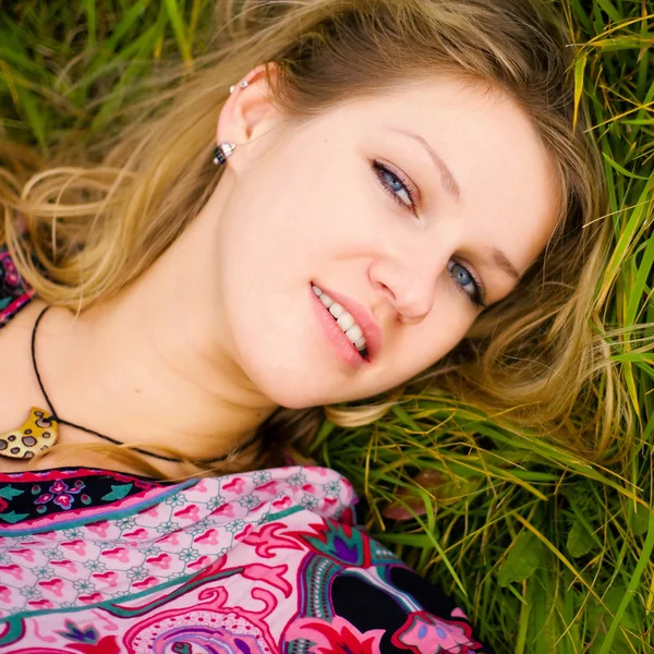 Blonde souriante allongée sur l'herbe — Photo