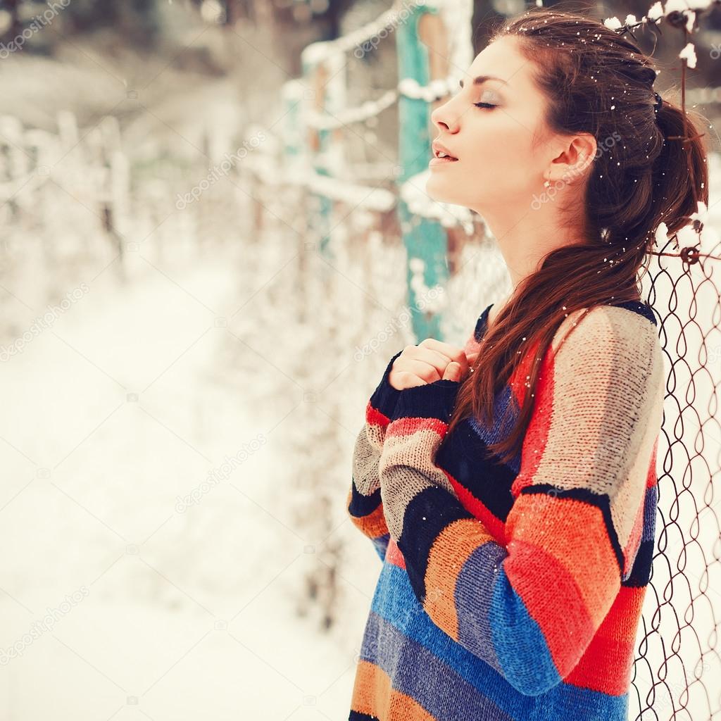 Beautiful brunette in winter with closed eyes.