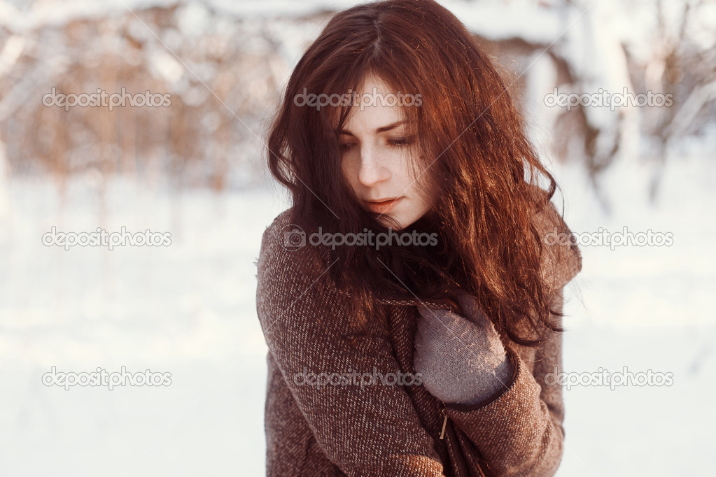 Young brunette in winter park.