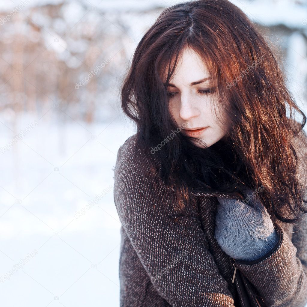 Young brunette in winter park.