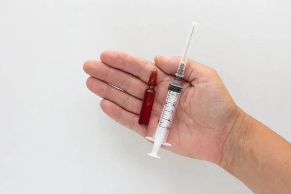 Vue du dessus de l'ampoule pour femme tenant la main avec des vitamines du groupe B pour injection et une seringue sur fond blanc — Photo