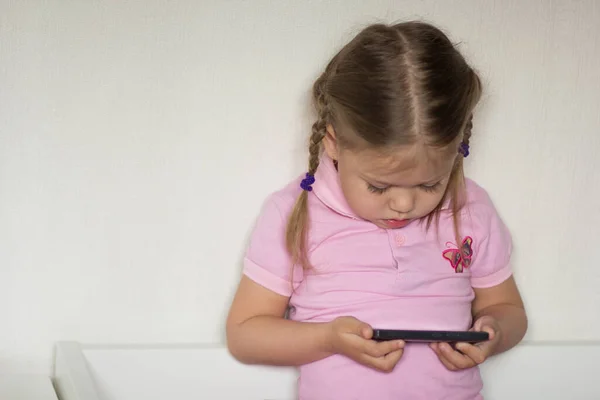 Кавказька Дитина Трирічного Віку Яка Тримає Мобільний Телефон Дивиться Нього Стокове Зображення