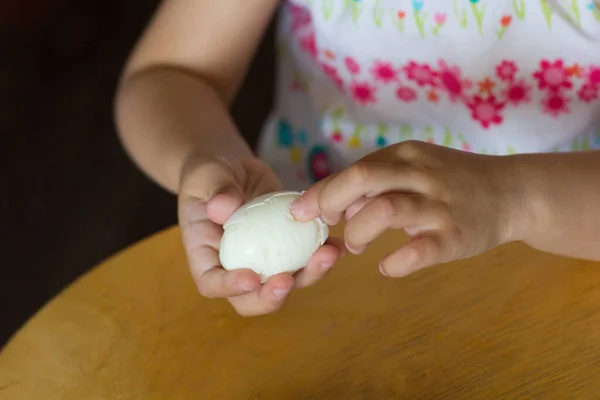 Main de l'enfant pelant l'oeuf arrachant la coquille — Photo