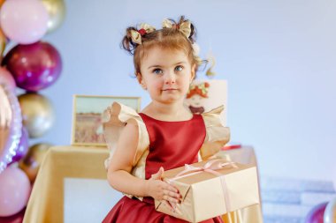 Lezzetli pastasının önünde doğum gününü kutlayan iki yaşındaki tatlı kızın yakın çekimi. Güzel bebek doğum günü fotoshop 'u