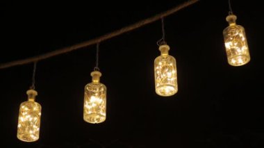 Yaratıcı öncü Mason Kavanozu lambaları ipte asılı ve rüzgarda sallanıyor