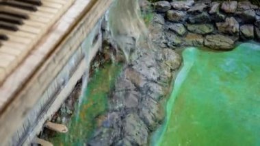 Klasik beyaz piyano bir şelaleye dönüştü. Bahçede akan küçük dekoratif şelale.