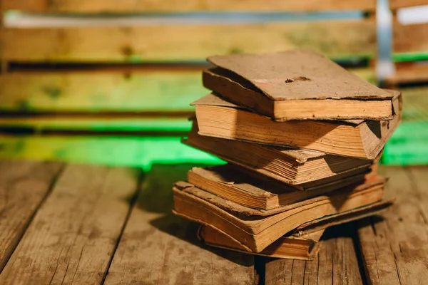 非常にほこりの多い、背景がぼやけた木製のボード上のアンティークの本のスタック — ストック写真