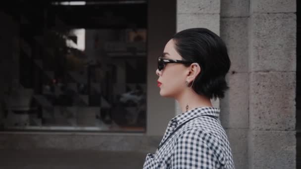 Estilo urbano tiro de moda de jovem mulher sedutora decolando óculos de sol e posando para câmera — Vídeo de Stock