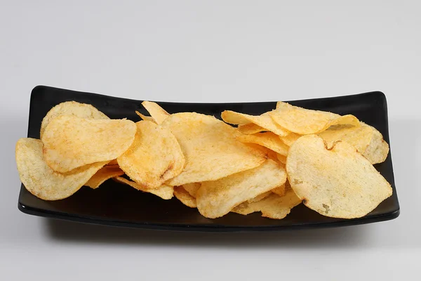 Patatas fritas en plato negro — Foto de Stock