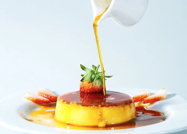 Pouring caramel on lemon pudding — Stock Photo, Image