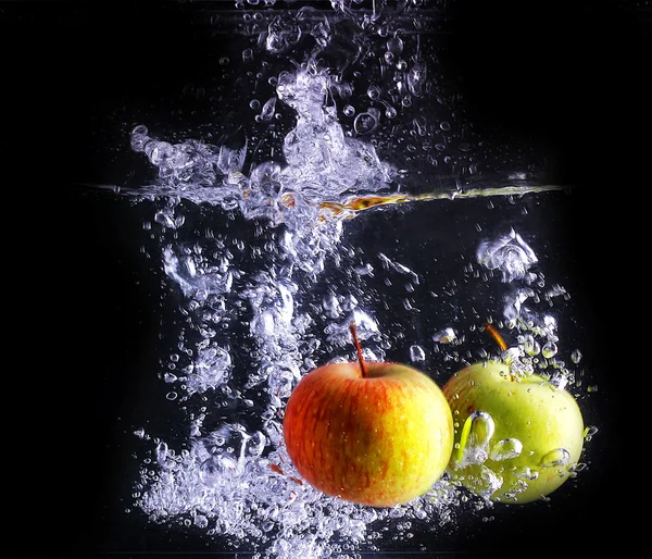 Deux pommes font des bulles, isolées avec un fond noir — Photo