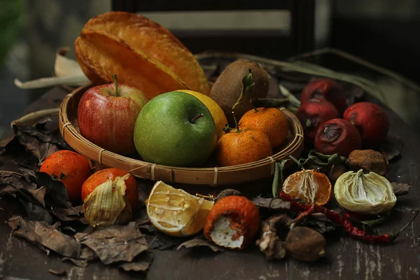 Niektóre owoce i zgniłe warzywa na krzesło tekowe — Zdjęcie stockowe