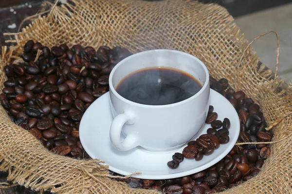 Une tasse de boissons et de grains de café — Photo