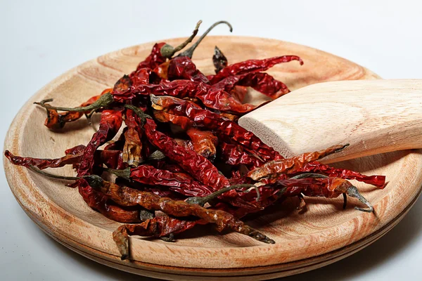 Dry red chilies and wooden grinder, white back ground — Stock Photo, Image