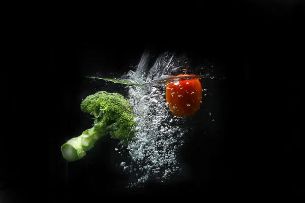 broccoli and tomato splashing
