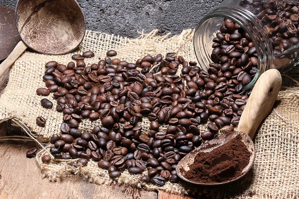 Kaffeebohnen auf Jute gießen, Steinhintergrund — Stockfoto