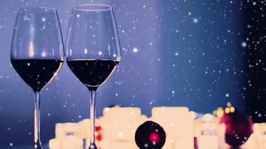 Romantik kış buluşması gecesi geçmişi, şarap bardakları ve karlı mumlar ve tatil simleri.