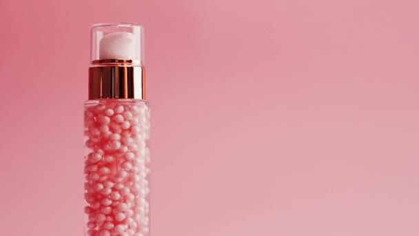 Пляшка для догляду за шкірою на рожевому тлі, краса та косметика — стокове відео