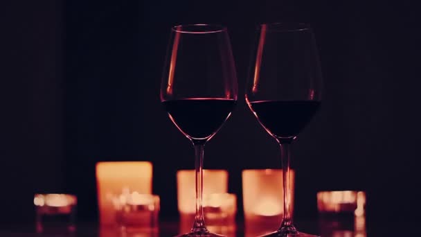 Romântico data noite fundo, copos de vinho tinto e velas douradas — Vídeo de Stock