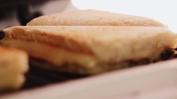 Gorące trójkątne kanapki z serem gotowane w tosterze kanapkowym, domowe jedzenie komfort — Wideo stockowe