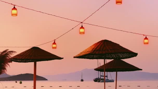 Parapluies, lanternes, mer et montagne au coucher du soleil, décoration extérieure et vacances d'été b-roll — Video