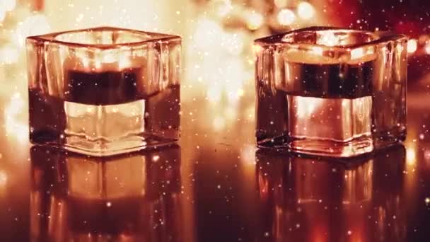 Золотые свечи и праздничные блестки на романтическом фоне, золотые частицы текут вверх по течению — стоковое видео
