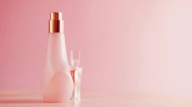 Pembe arka planda güzellik ürünü tanıtımı olarak kadınsı çiçek kokusuna sahip parfüm ve parfüm.
