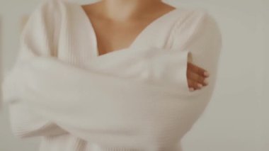 Sıcak beyaz örgü süveter ya da soğuk mevsimde giyilen elbise, dinlenme odası kıyafeti ve sürdürülebilir moda giyen bir kadın.