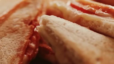 Sandviç tost makinesinde pişirilmiş sıcak üçgen peynirli sandviçler, ev yapımı konforlu yemekler.