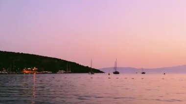 Yaz aylarında deniz manzarası, deniz ve dağlar üzerinde romantik günbatımı, seyahat yerleri, plaj kaçamakları ve yaz tatilleri.
