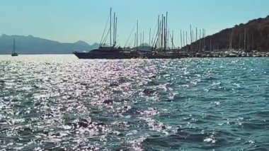 Gün batımında tekneler ve yatlarla yavaş çekim sahnesi. Deniz, yat ve seyahat konsepti.