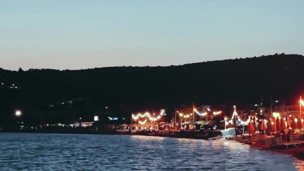 日没時の海辺の町の風景、旅行や自然コンセプト、海の波とライト — ストック動画