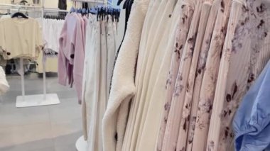 Moda, perakende ve alışveriş konsepti, giyim mağazasındaki askılarda çeşitli şık kıyafetler.